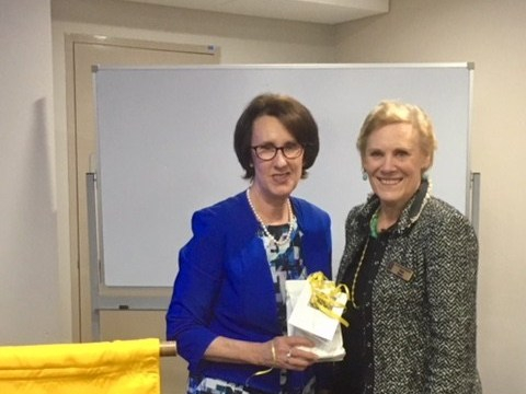 A picture of two women smiling at the camera. One is holding a thank you gift