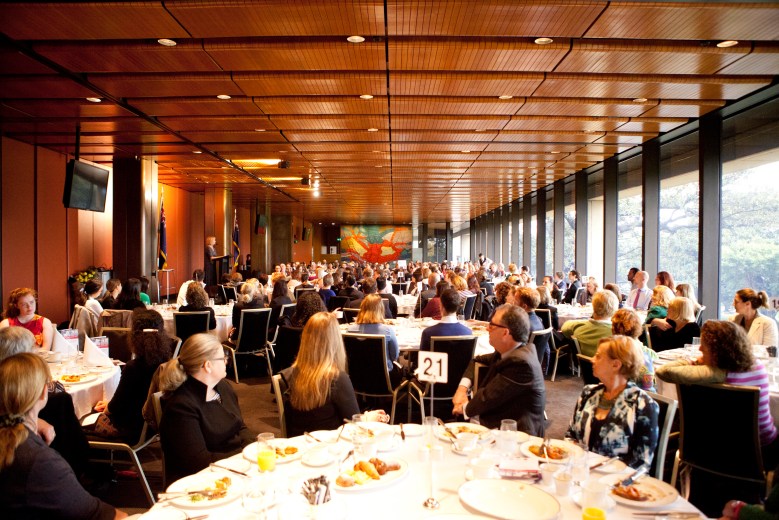 Picture of people listening to a speaker and sitting at a number of tables