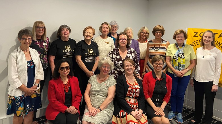 A group of women posing in front of a sign saying Zonta International